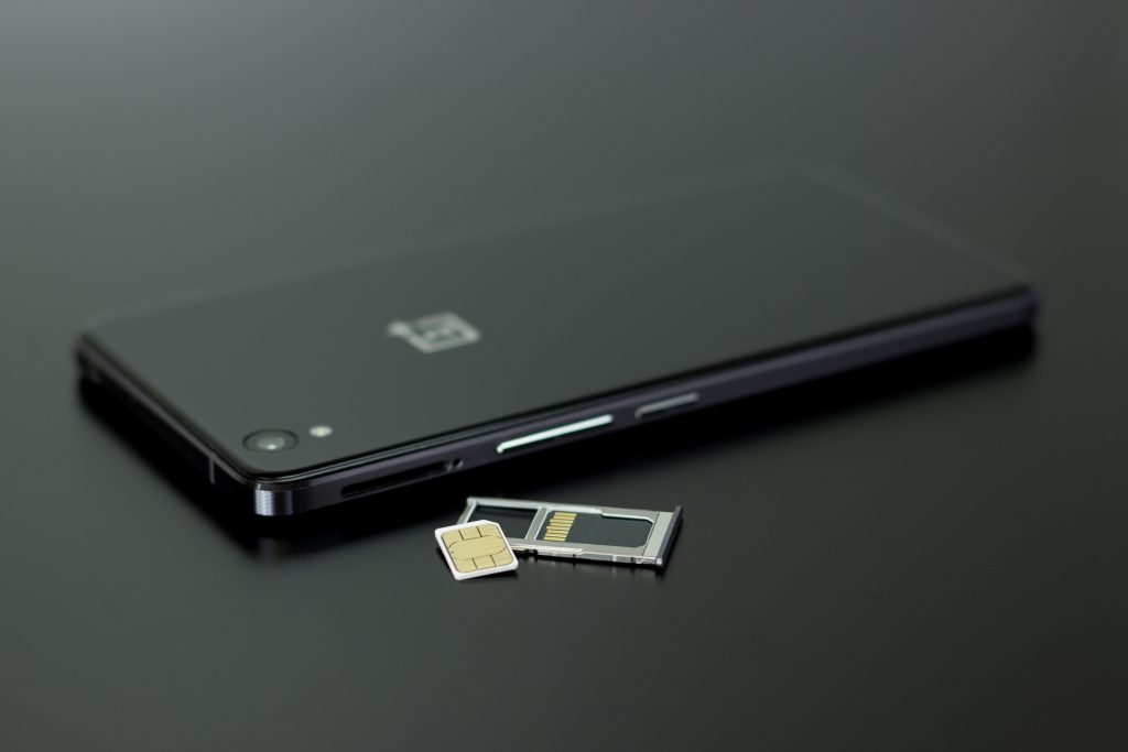 Smart phone facedown with SIM card laying next to it