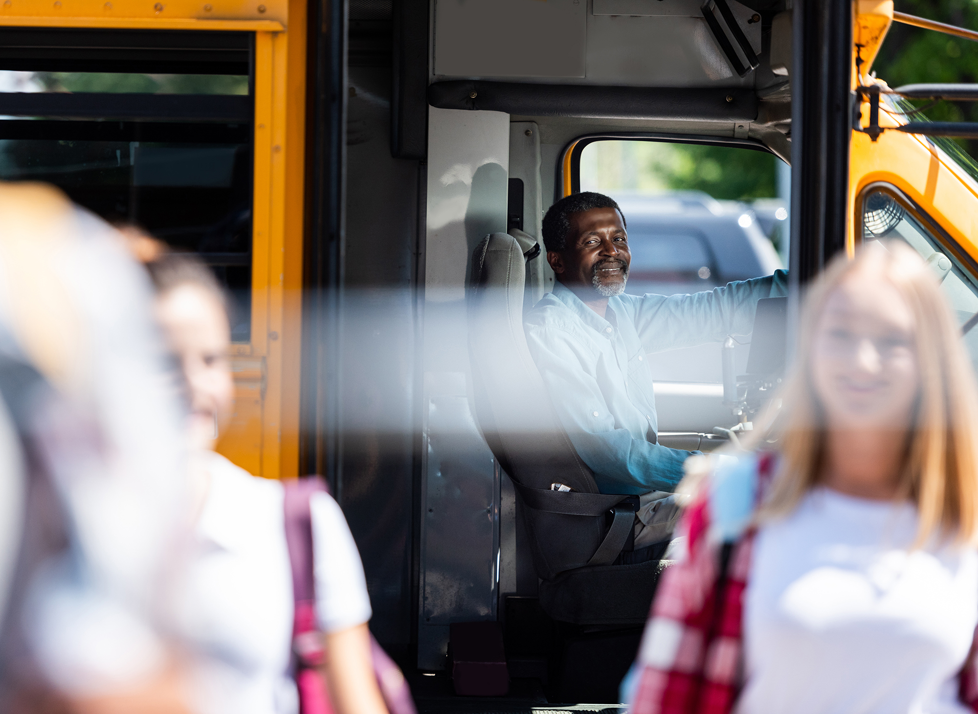 jacs-solutions-cheerful-school-bus-driver-in-organized-student-transport 2000x1460