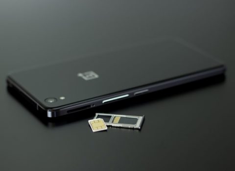 Smart phone facedown with SIM card laying next to it