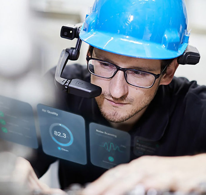 Technician using RealWear headset with wireless connectivity to repair manufacturing facility part