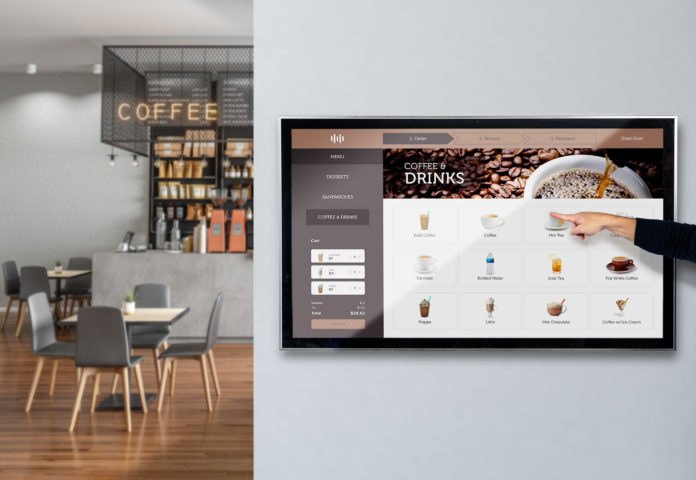 Man using JACS Solutions TS5503 55" touchscreen display to order food in retail coffee shop.