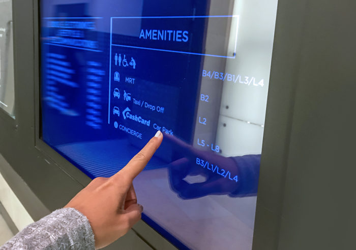 Traveler using POE touchscreen display for wayfinding in a retail mall