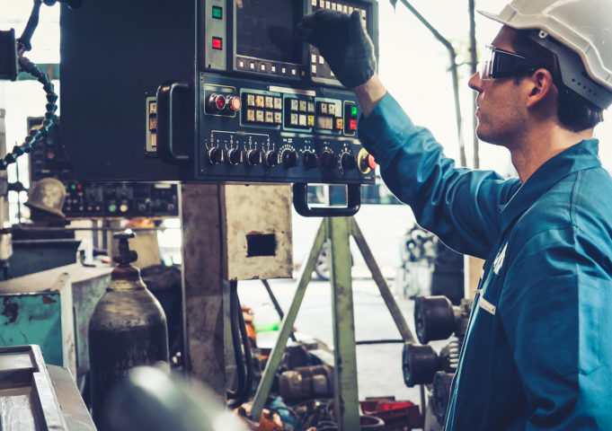 Industrial worker in factory using technology to run diagnostics.