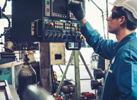 Industrial worker in factory using technology to run diagnostics.