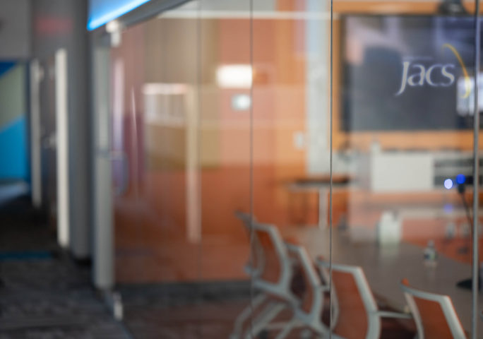 Orange conference room photo of the JACS Solutions office interior.