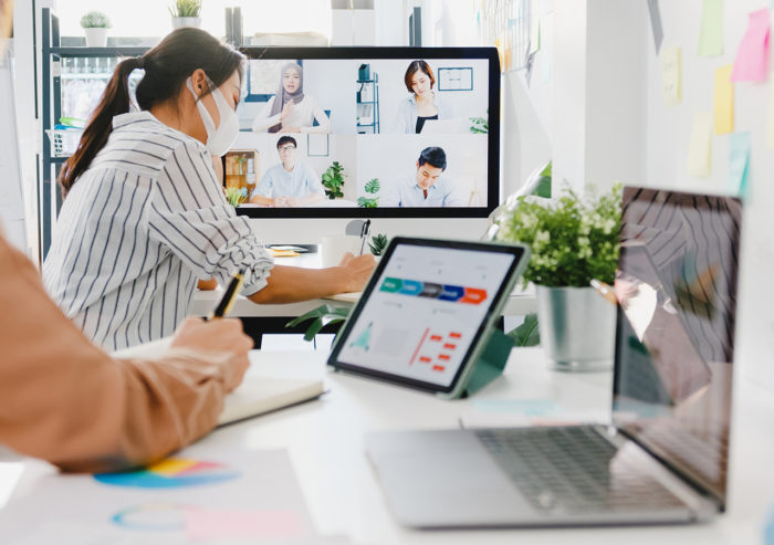 Woman working in remote office using wifi on tablet, laptop and desktop.