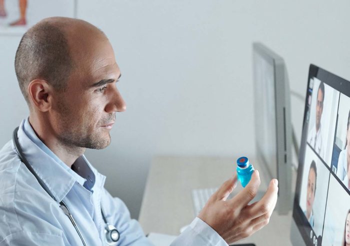 Doctor in office collaborating with healthcare professionals remotely to discuss medications