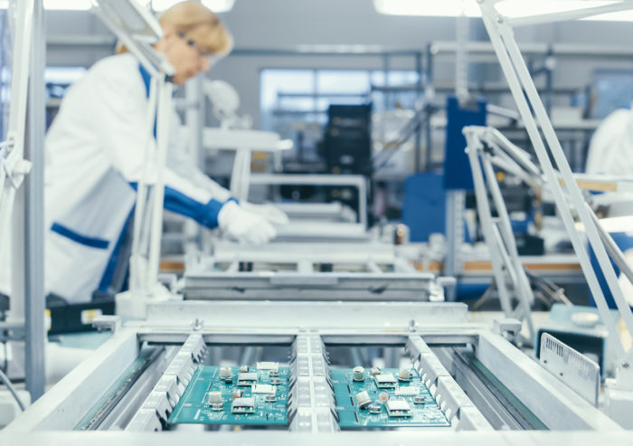 Assembly line in factory with workers building and assembling custom tablet solutions