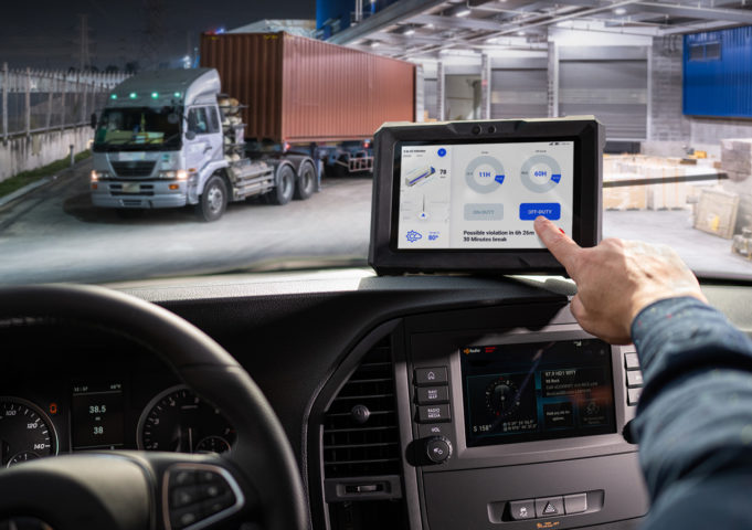 Truck driver using JACS Solutions TT800V rugged tablet to log delivery route data.